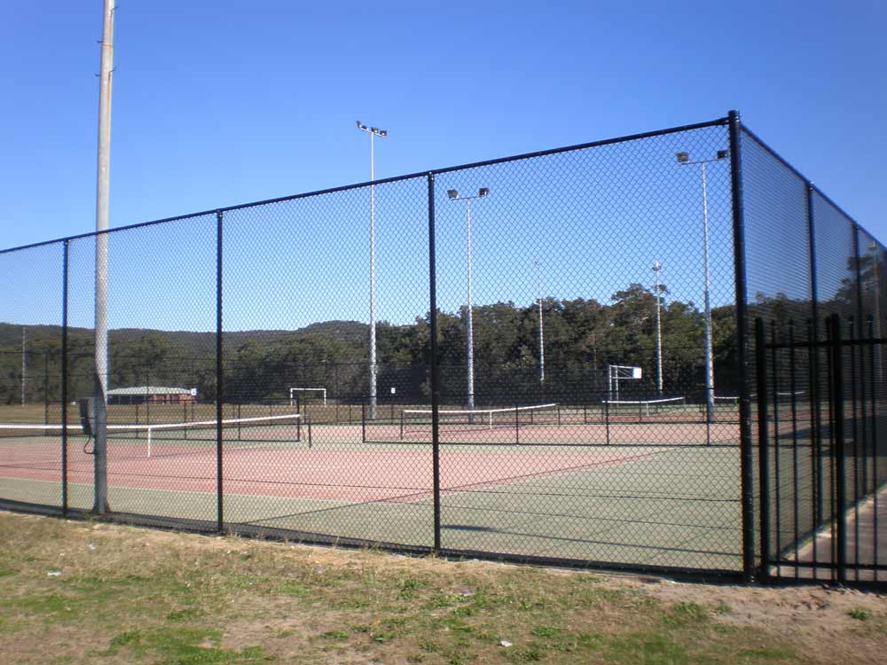 Black chain wire fencing around tennis courts