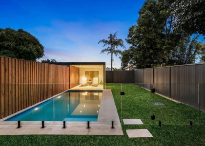 Glass pool fencing beside a lap pool with timber screen fencing