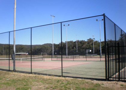 Black chain wire fencing around tennis courts